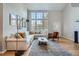 Bright living room with large windows, vaulted ceilings, hardwood floors, and comfortable sectional couch at 8300 Fairmount Dr # Aa102, Denver, CO 80247