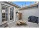 Cozy patio area with gray pavers, outdoor furniture, grill, and a small wooden gate at 8300 Fairmount Dr # Aa102, Denver, CO 80247