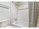 Bright, tiled bathtub with a black and white striped shower curtain for a fresh, minimalist vibe at 1160 S Clinton St # 40, Denver, CO 80247
