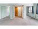 Bedroom with sliding mirrored closet doors, plush carpeting, and views into another room at 1160 S Clinton St # 40, Denver, CO 80247