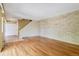 Open living area with hardwood flooring, light brick wall, and staircase in view at 1160 S Clinton St # 40, Denver, CO 80247