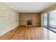 Spacious living room with fireplace, light brick accent wall, and sliding glass door at 1160 S Clinton St # 40, Denver, CO 80247