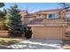 Front exterior of home featuring a two-car garage, tile roof, and well-manicured lawn at 8822 Fiesta Ter, Lone Tree, CO 80124