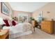 Comfortable bedroom features a floral comforter, wicker furniture, and a window view for a cozy retreat at 6819 S Webster St # E, Littleton, CO 80128