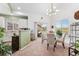 Bright dining area featuring a table for four, modern chandelier, and access to the balcony at 6819 S Webster St # E, Littleton, CO 80128