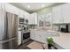Modern kitchen with stainless steel appliances, white cabinets, and tile floors at 6819 S Webster St # E, Littleton, CO 80128