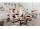Inviting living room featuring a staircase, sofa, glass table, and a view of the dining area at 6819 S Webster St # E, Littleton, CO 80128