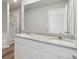 Bathroom featuring double sinks with granite countertop, glass shower, and white cabinets at 7303 Dolores Ave, Frederick, CO 80530