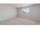 Bedroom with a large window providing natural light and neutral carpet at 7303 Dolores Ave, Frederick, CO 80530