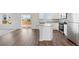 Open-concept kitchen and living room with hardwood floors and sliding glass doors at 7303 Dolores Ave, Frederick, CO 80530