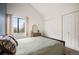 Bright bedroom featuring a comfortable bed, vaulted ceiling, closet space and a window with neighborhood views at 3600 S Pierce St # 1-207, Denver, CO 80235
