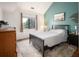 Inviting bedroom with a teal accent wall, modern decor, wood floors, and natural light from the window at 3600 S Pierce St # 1-207, Denver, CO 80235