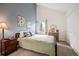 Cozy bedroom with vaulted ceiling, earth-toned walls, bedside table, and natural light from the window at 3600 S Pierce St # 1-207, Denver, CO 80235