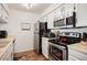 Compact kitchen with stainless steel appliances and neutral color scheme at 3600 S Pierce St # 1-207, Denver, CO 80235