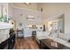Open living room with stone fireplace, bar cart, and seamless flow into the adjacent kitchen at 3600 S Pierce St # 1-207, Denver, CO 80235