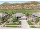 Aerial view of a landscaped single Gathering home on a green lot with mountain views, an attached garage and fenced yard at 4868 Hogback Ridge Rd, Morrison, CO 80465