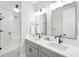 Modern bathroom featuring double vanity, sleek mirrors, and a glass-enclosed shower at 4868 Hogback Ridge Rd, Morrison, CO 80465