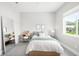 A cozy bedroom bathed in natural light from a large window, features neutral tones at 4868 Hogback Ridge Rd, Morrison, CO 80465