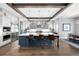 The kitchen boasts an island with seating, stainless appliances, and beamed ceilings at 4868 Hogback Ridge Rd, Morrison, CO 80465