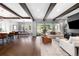 Open living room features beautiful hardwood floors, beamed ceilings, fireplace, and access to outdoor space at 4868 Hogback Ridge Rd, Morrison, CO 80465