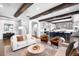 The living room features hardwood floors, beamed ceilings, and an open floor plan with access to the kitchen at 4868 Hogback Ridge Rd, Morrison, CO 80465