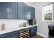 Stylish butler's pantry featuring custom blue cabinets, counterspace, and a wine rack at 4868 Hogback Ridge Rd, Morrison, CO 80465