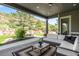 Covered patio offers a cozy seating area with views of the landscaped yard and scenic mountains at 4868 Hogback Ridge Rd, Morrison, CO 80465