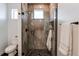 Modern bathroom features a glass shower with stone tile and mosaic floor, complemented by a sleek black towel rack at 8 S Colorado Blvd, Denver, CO 80246