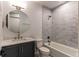 Stylish bathroom features a bathtub-shower, sleek gray tile, a modern vanity with a round mirror and marble countertop at 8 S Colorado Blvd, Denver, CO 80246