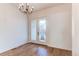 Bright dining room featuring elegant chandelier, wood floors, and French doors leading to a landscaped front yard at 8 S Colorado Blvd, Denver, CO 80246