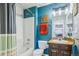Well lit bathroom with bathtub, shower and single sink vanity with turquoise blue wall at 4730 Copeland Cir # 203, Highlands Ranch, CO 80126