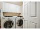 Bright laundry room with washer and dryer and overhead cabinets at 4730 Copeland Cir # 203, Highlands Ranch, CO 80126