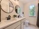 Modern bathroom featuring double sinks, decorative mirrors and fixtures, and a window with a view at 5206 S Meadow Lark Dr, Castle Rock, CO 80109
