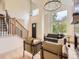 Bright living room featuring high ceilings, elegant chandeliers, and a staircase with iron railings at 5206 S Meadow Lark Dr, Castle Rock, CO 80109