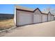 The garages are separate from the main property and feature a grey exterior and white doors at 8391 S Upham Way # 209, Littleton, CO 80128