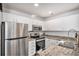 Well-lit kitchen featuring white cabinets, granite countertops, and stainless steel appliances at 8391 S Upham Way # 209, Littleton, CO 80128