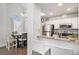 Bright kitchen with white cabinets, stainless steel appliances, and granite countertops open to dining area at 8391 S Upham Way # 209, Littleton, CO 80128