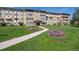Well-maintained condo building with manicured lawn and colorful flower beds leading to the entrance at 635 S Alton Way # 3B, Denver, CO 80247