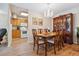 Dining area with chandelier, wood floors, and view of updated kitchen at 635 S Alton Way # 3B, Denver, CO 80247