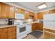 Traditional kitchen featuring wooden cabinets, white appliances, and a laminate countertop at 635 S Alton Way # 3B, Denver, CO 80247