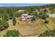 Aerial view showcasing a large property with a fenced yard surrounded by mature trees at 18680 Knollwood Blvd, Monument, CO 80132