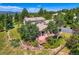 Aerial view showcasing the home, large deck, and surrounding landscape with mature trees at 18680 Knollwood Blvd, Monument, CO 80132