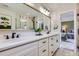 Renovated bathroom provides double sinks, modern lighting, white cabinetry, and tasteful decor at 18680 Knollwood Blvd, Monument, CO 80132