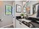 Modern bathroom featuring a sleek black granite countertop, framed mirror, and contemporary fixtures at 18680 Knollwood Blvd, Monument, CO 80132