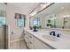 Bright bathroom boasts double sinks, modern lighting, white cabinetry, and wood look flooring at 18680 Knollwood Blvd, Monument, CO 80132