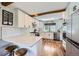 Bright, updated kitchen with white cabinetry, stainless steel appliances, and breakfast bar at 18680 Knollwood Blvd, Monument, CO 80132