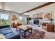 Cozy living room with fireplace, exposed wood beams, and scenic views at 18680 Knollwood Blvd, Monument, CO 80132