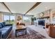 Large living room with stylish brick fireplace, exposed beams, and picturesque windows at 18680 Knollwood Blvd, Monument, CO 80132
