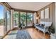 Inviting sun room with wood paneling, hardwood floors, and large windows offering scenic views at 18680 Knollwood Blvd, Monument, CO 80132