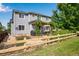 Backyard view of a two-story home, pergola-covered patio, fenced yard, and landscaped garden at 11830 Snowshoe Dr, Parker, CO 80138